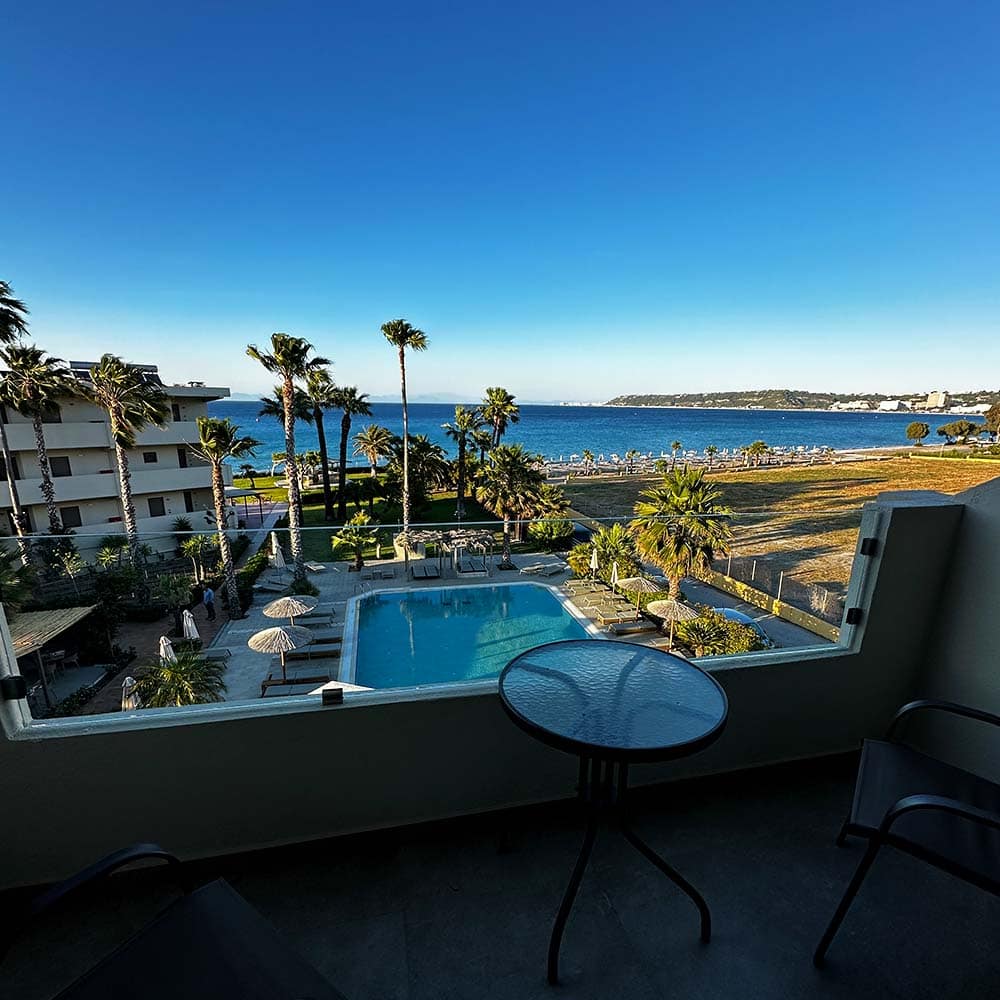 Skats no Ixia Dream Hotel balkona uz viesnīcas pagalmu un jūras krastu